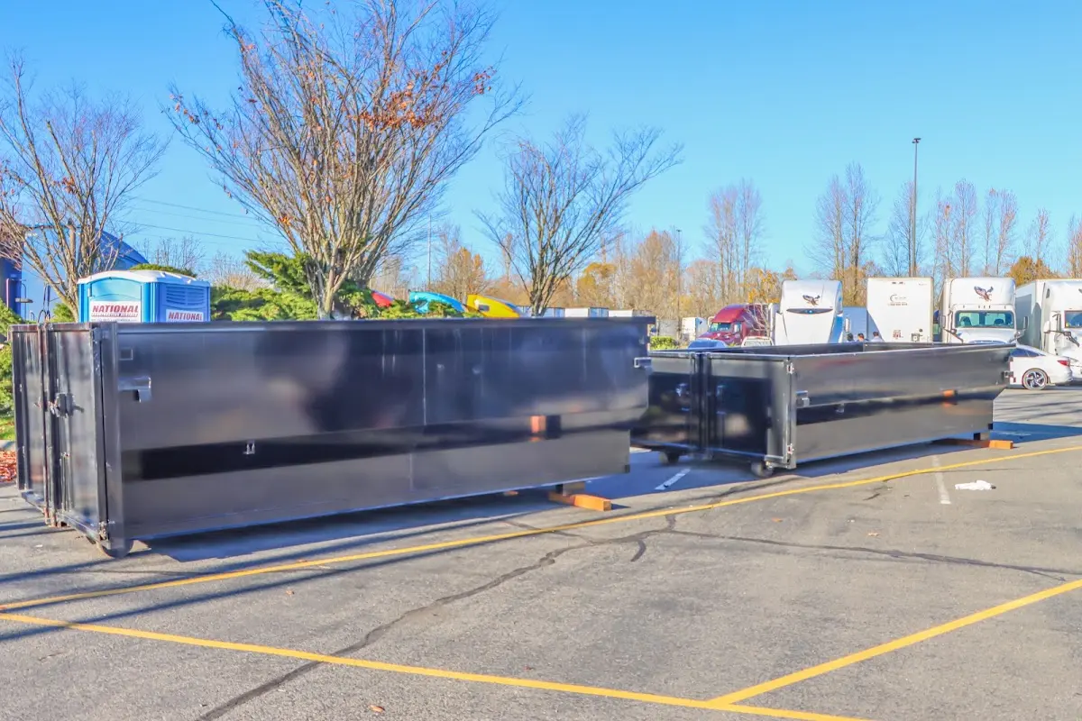 Professional dumpster rental service with roll-off container on residential driveway in Lyons